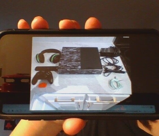 Gray Camo Xbox one with controller, headset, HDMI cord, charger, and a tv remote