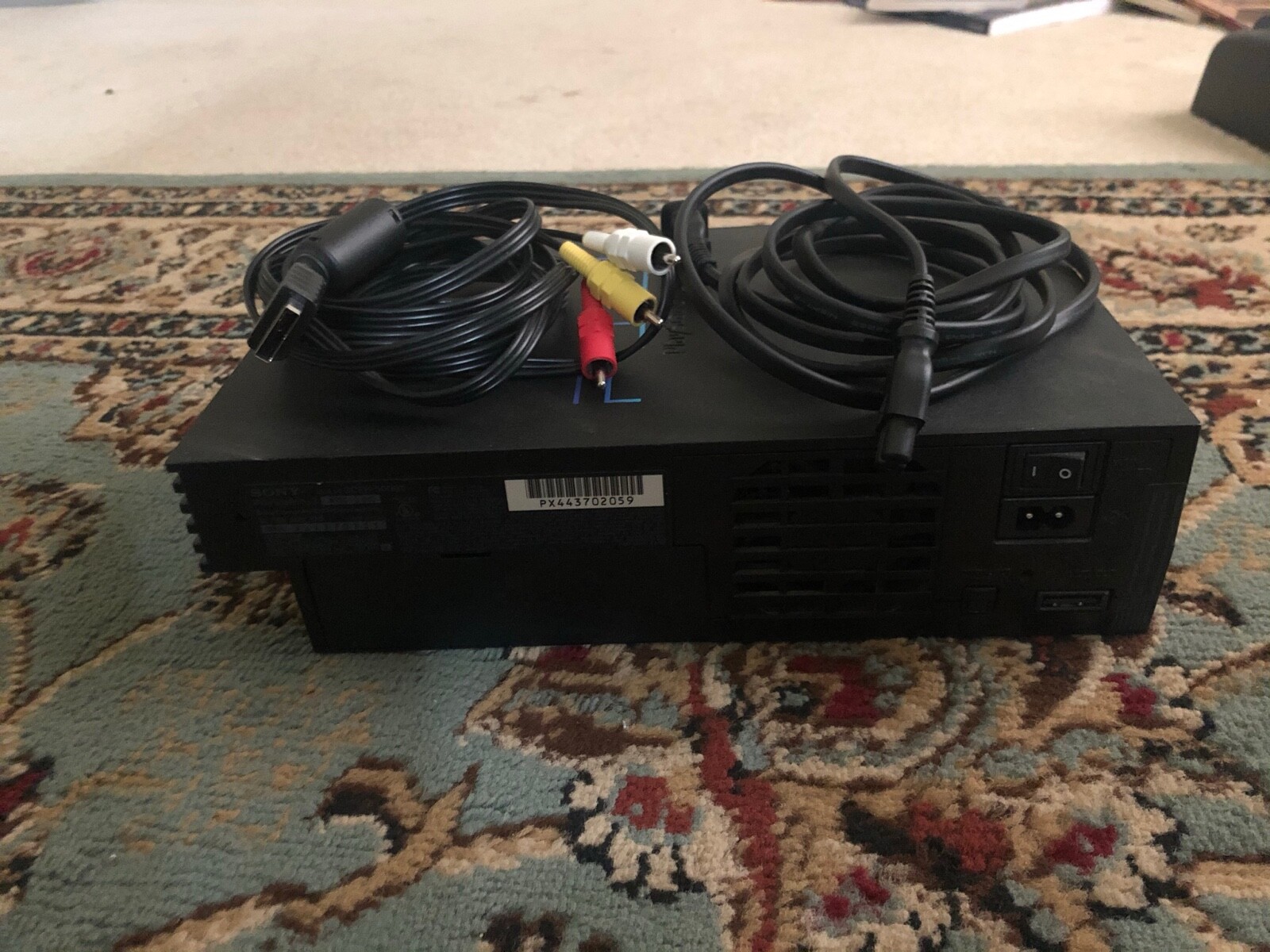 Black Sony PlayStation 2 lot with 2 controllers, 32 MB of memory, and 3 games.