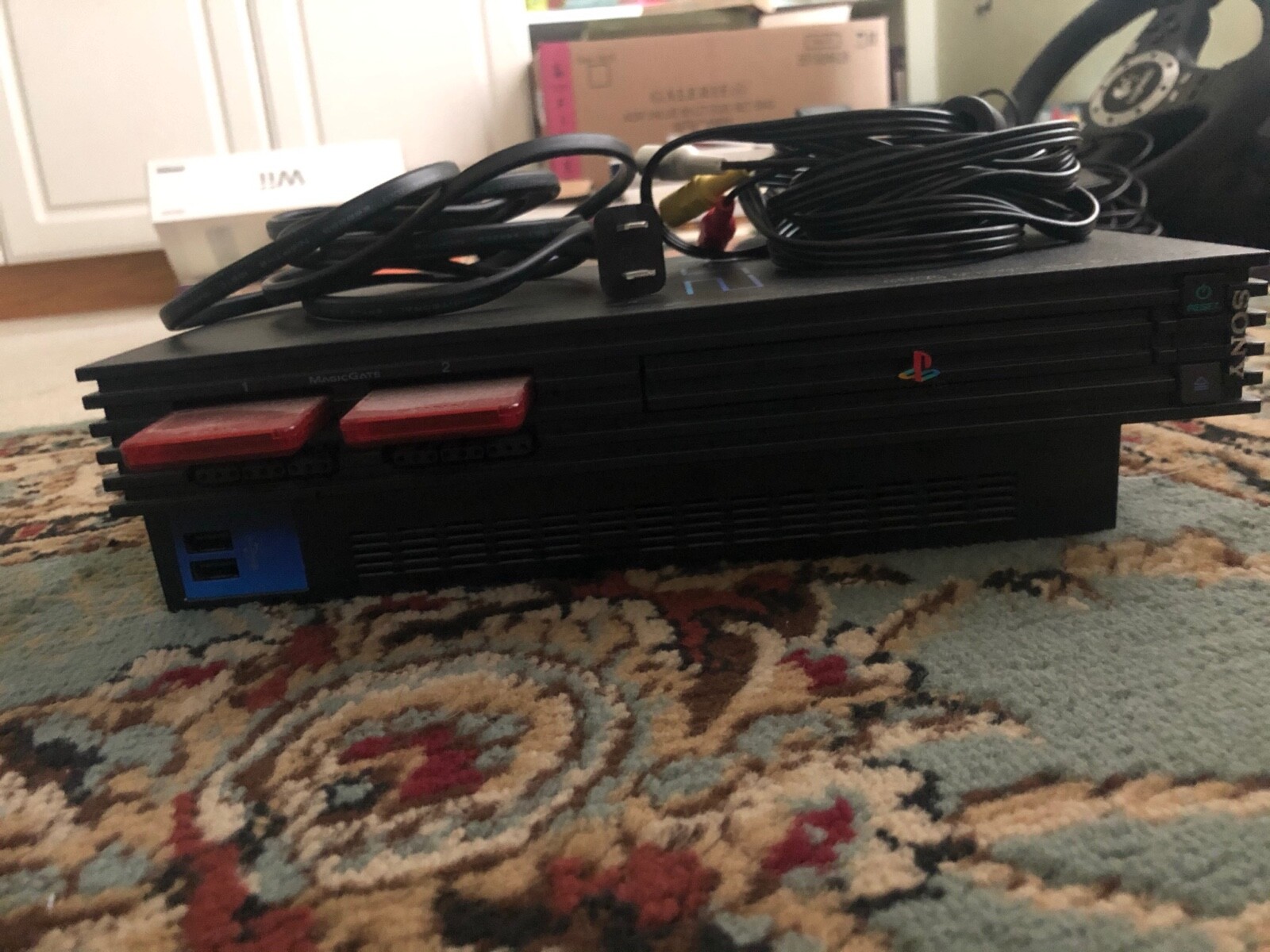 Black Sony PlayStation 2 lot with 2 controllers, 32 MB of memory, and 3 games.
