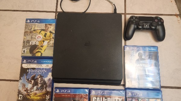 Sony PlayStation 4 Slim 500 GB Matte Black. Comes with 2 remotes and 7 games.