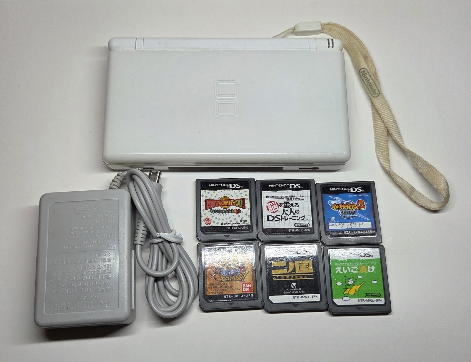 Nintendo DS Lite White + 6 Games, Charger, Nintendo Strap – Tested & Working