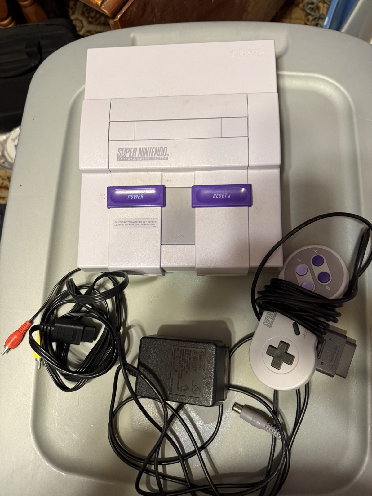 Super Nintendo Console, controller, game genie, and cleaning kit.