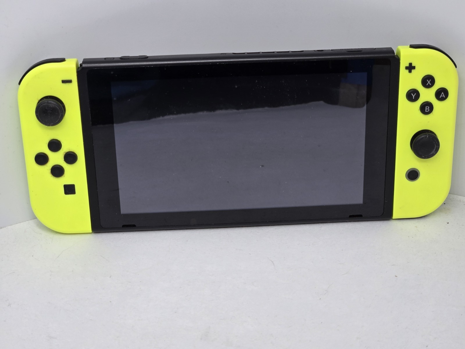 Vibrant Nintendo Switch console. Has black console with cool neon yellow…